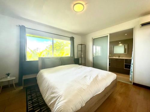 sypialnia z dużym białym łóżkiem i dużym oknem w obiekcie View apartment - St Barts w mieście Marigot