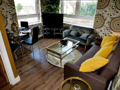 a living room with a couch and a table at Stunningly Opulent Gold Apartment Near Sheffield FULL SKY TV in Rotherham