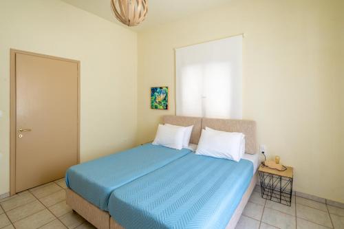 1 dormitorio con 1 cama con sábanas azules y almohadas blancas en Casa Cicala, en Pómbia