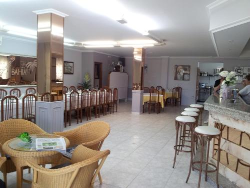 a restaurant with chairs and tables and a bar at Hotel Bahia in O Grove