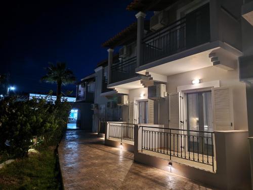 a white house with a balcony at night at Cavo Garden in Kavos