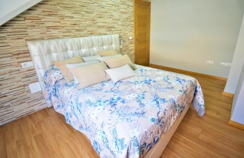 a bedroom with a bed with blue and white sheets and pillows at Ático de playa con vistas en Baltar - Sanxenxo in Portonovo
