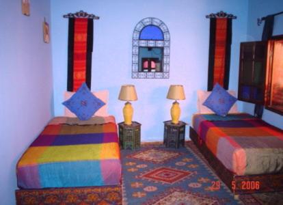 a bedroom with two beds and two lamps on tables at Ryad Bahia in Meknès