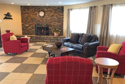 a living room with red chairs and a fireplace at Affordable Inns Evanston in Evanston