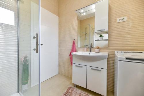 ein Badezimmer mit Waschbecken und Dusche in der Unterkunft Family apartment Amare in Zadar