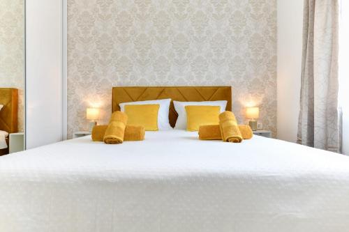 ein Schlafzimmer mit einem großen weißen Bett mit gelben Kissen in der Unterkunft Family apartment Amare in Zadar