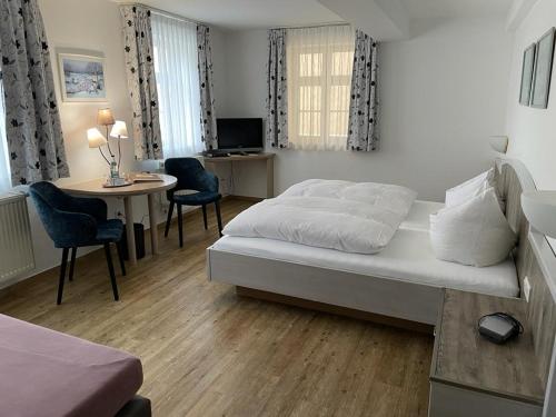 1 dormitorio con 1 cama y 1 mesa con sillas en Hotel Gasthof Krapp en Scheßlitz
