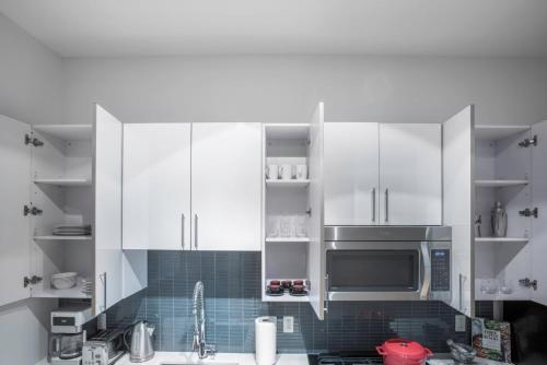a kitchen with white cabinets and a microwave at Airy studio in Sie w Gym Doorman BOS-17 in Boston