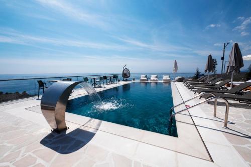 - une piscine avec une fontaine dans un complexe dans l'établissement Casa Del Sol - Luxury Villas, à Himarë