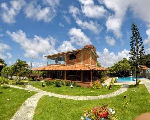 a large house with a yard with a swimming pool at Chácara da Bel in Pitimbu