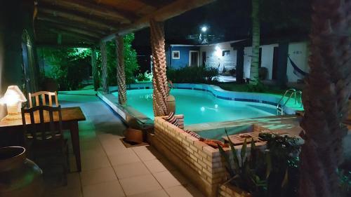 a swimming pool at night with a resort at Pousada La Luna in Paracuru