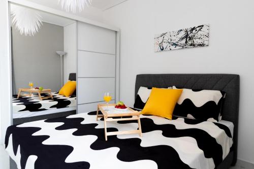 a bedroom with a black and white bed and yellow pillows at Z5 Sky Sparta Apartment in Sparti