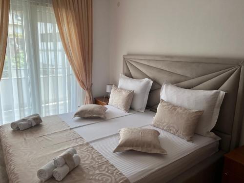 - une chambre dotée d'un grand lit avec des draps et des oreillers blancs dans l'établissement Apartments Magdalena, à Stobreč