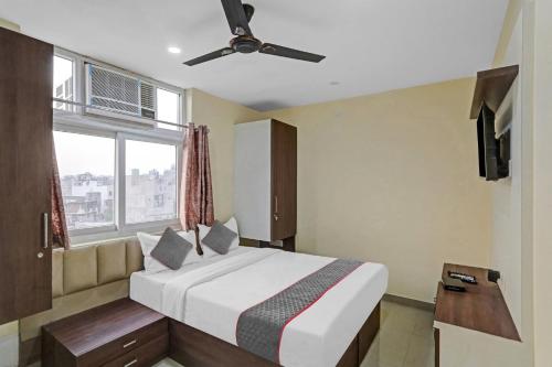 - une chambre avec un lit, un ventilateur de plafond et une fenêtre dans l'établissement Meera Eternity, à Noida