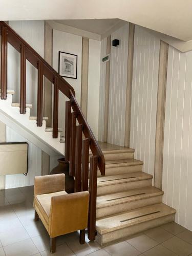 a staircase in a house with a chair at Hotel Cavaleiros De Cristo in Tomar