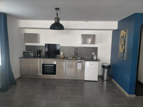 a kitchen with stainless steel appliances and a tile floor at L'escale du désir, Spa privatif in Calais