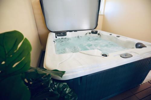 a bathroom with a bath tub with a plant at Markó Vendégház in Kiskőrös