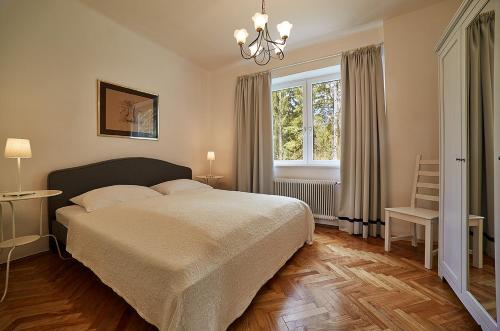 a bedroom with a bed and a window at Seeappartements Eden in Pörtschach am Wörthersee