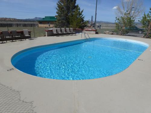 una grande piscina blu con sedie intorno di Bryce Canyon Resort a Bryce Canyon