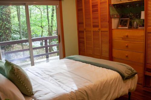 1 dormitorio con cama, ventana y vestidor en Modern Cabin With Hot Tub Grill Lake Beach Wineries Hiking Fishing And Hershey Park Family And Pet Friendly Superhosts On AB&B, en Mount Gretna