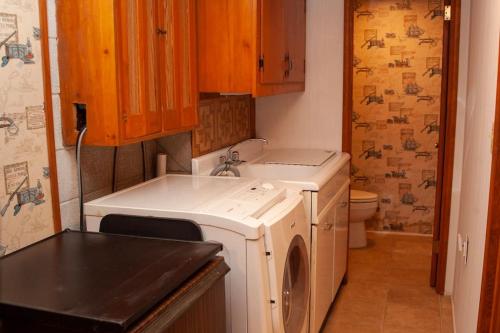 a small kitchen with a washing machine and a sink at Modern Cabin With Hot Tub Grill Lake Beach Wineries Hiking Fishing And Hershey Park Family And Pet Friendly Superhosts On AB&B in Mount Gretna
