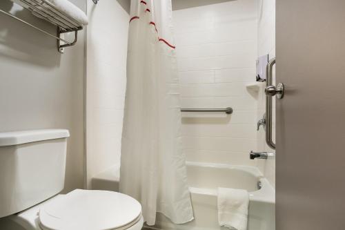 a small bathroom with a toilet and a shower at Red Roof Inn Denver in Denver