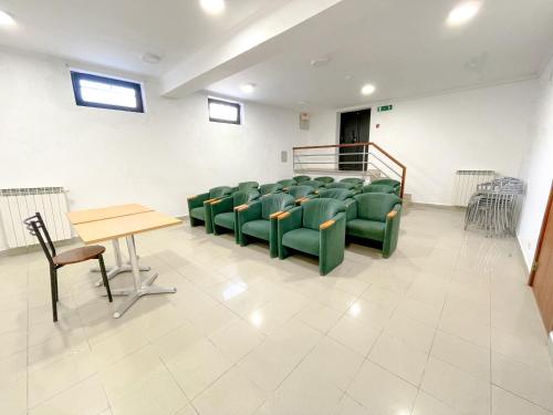 a waiting room with green chairs and a table at HI Areia Branca - Pousada de Juventude in Areia Branca