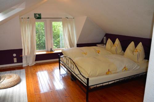 1 dormitorio con 1 cama grande con sábanas y almohadas blancas en Wohnidylle auf schönem Anwesen im Wald, en Bad Honnef am Rhein