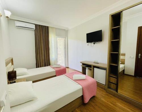 a hotel room with two beds and a television at Sea Line Hotel in Shekvetili