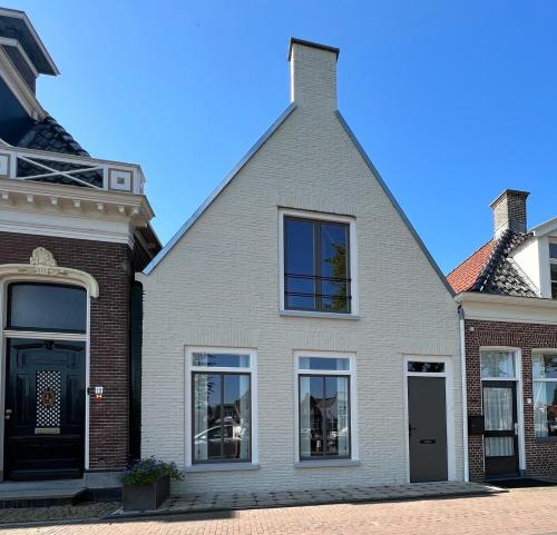 a white house with a black door and windows at Dok 20, Lemmer in Lemmer