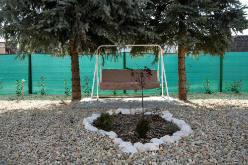 a swing in the middle of two trees at Markó Vendégház in Kiskőrös