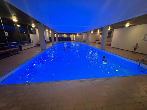 a large blue pool with people swimming in it at Appartamento vacanza Top Residence in Passo del Tonale