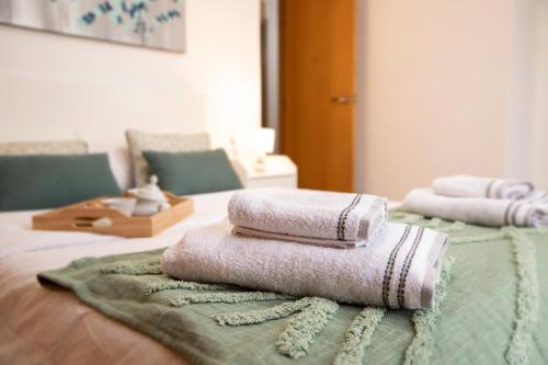 uma pilha de toalhas sentadas em cima de uma cama em Grand Villa em Valência