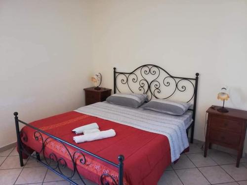 a bedroom with a red and white bed with two towels at Agriturismo La Palombara in Paola