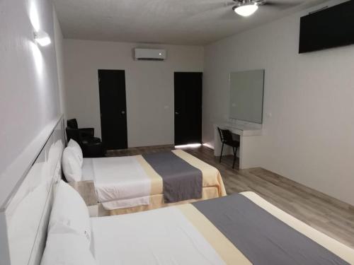 Pokój hotelowy z 2 łóżkami i biurkiem w obiekcie Hotel Gallo w mieście Guadalajara