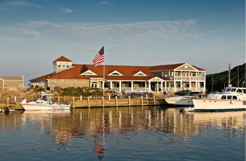 a large house with boats docked in the water at Ballard's Beach Resort in New Shoreham