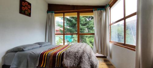 a bedroom with a bed and a large window at Cabaña Papá Beto in Mineral del Monte