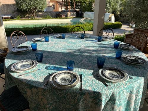 a table with a blue table cloth and plates on it at Gîte Blanche de Rouquette in Paulhan