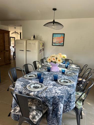 a dining room table with a blue and white table cloth at Gîte Blanche de Rouquette in Paulhan