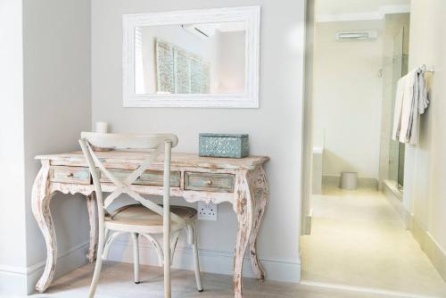 tocador con silla y espejo en 13 La Gratitude Luxury Apartment-with backup power for loadshedding, en Stellenbosch