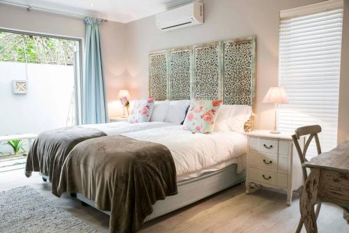 Un dormitorio con una cama grande y una ventana en 13 La Gratitude Luxury Apartment-with backup power for loadshedding, en Stellenbosch