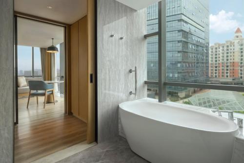 La salle de bains est pourvue d'une baignoire et d'une fenêtre. dans l'établissement Courtyard by Marriott Foshan Gaoming, à Foshan