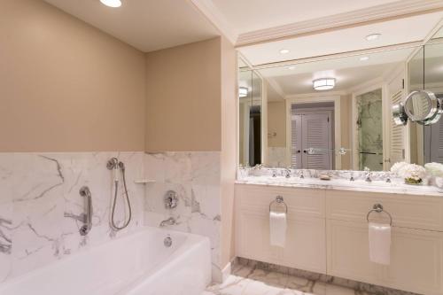 a bathroom with a tub and a large mirror at The Ritz-Carlton Naples, Tiburón in Naples