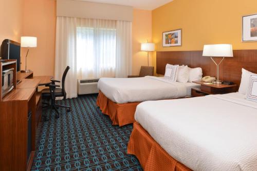 a hotel room with two beds and a desk at Fairfield Inn Jacksonville Orange Park in Orange Park