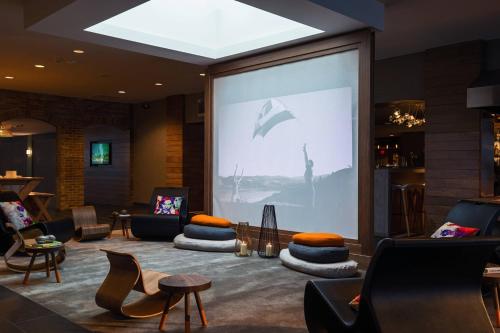 a large screen in a room with chairs and tables at Renaissance Minneapolis Bloomington Hotel in Bloomington