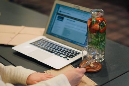 a person sitting at a table with a laptop and a glass jar at Renaissance Minneapolis Bloomington Hotel in Bloomington