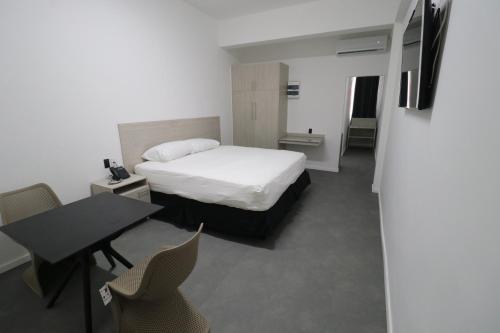 a bedroom with a bed and a table and chairs at Hotel Royal Brasil in Paramaribo
