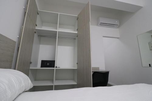 a bedroom with a bed and a book shelf at Hotel Royal Brasil in Paramaribo