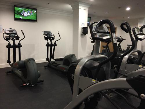 a gym with cardio machines and a television on a wall at Century Plaza Hotel in Vancouver