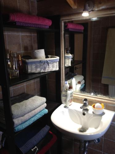 a bathroom with a sink and a mirror and towels at Liopi Village Andros in Órmos